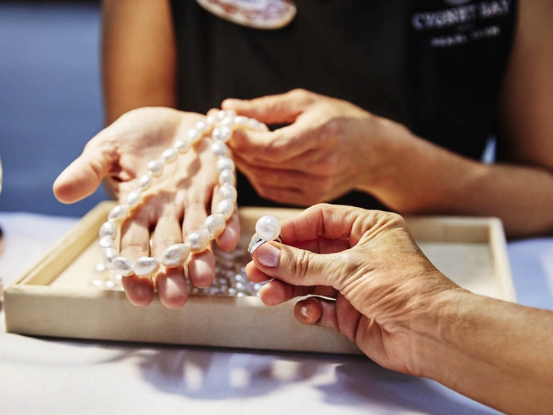 International tourists browsing elegant necklaces earrings and rings crafted from locally cultivated pearls near the famous Corona Casino Phu Quoc complex