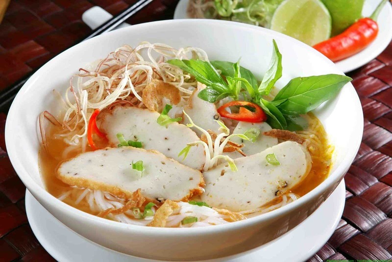 Travelers discovering the traditional flavors of Banh Canh Cha Ca fish cake noodle soup during their vacation at the prestigious Corona Casino Phu Quoc