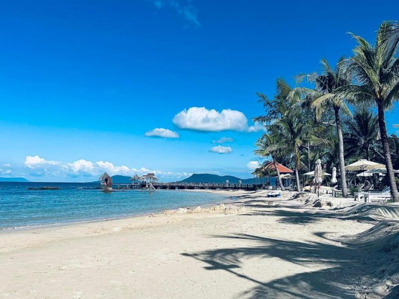 A professional landscape of the peaceful private beach at Gold Coast Resort Phu Quoc highlighting the coastal beauty for patrons of Corona Casino Phu Quoc