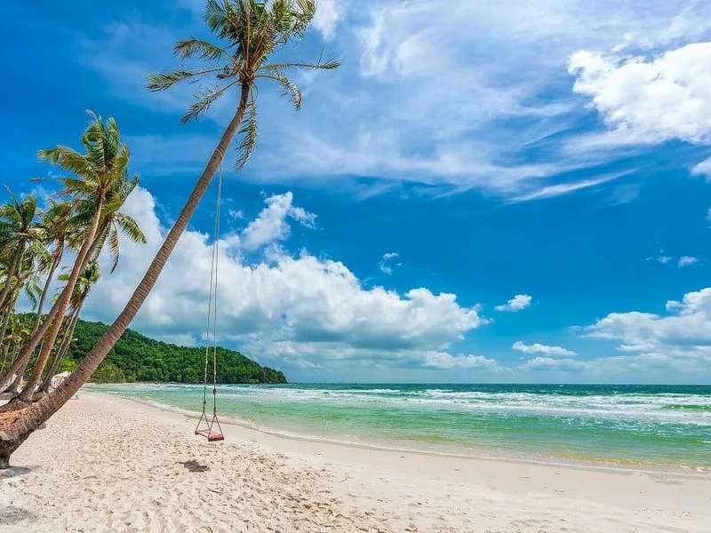 Chiếc xích đu dây thừng treo trên thân dừa nghiêng bên bờ cát trắng mịn tại Bãi Trào Hòn Thơm khi du lịch Phú Quốc tháng 5, gần Corona Resort & Casino Phú Quốc