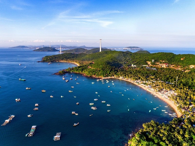 An aerial view of the An Thoi Archipelago coastline and islands connected by cable car towers, a highlight of a Phu Quoc 7-day itinerary recommended by Corona Resort & Casino Phu Quoc