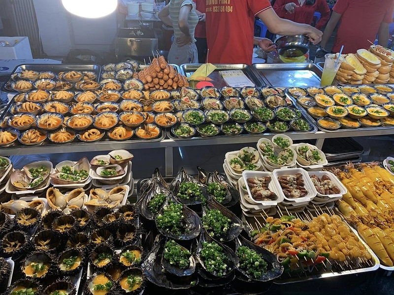 Busy street food counter displaying grilled squid and local delicacies on a Phu Quoc food tour near Corona Resort & Casino Phu Quoc