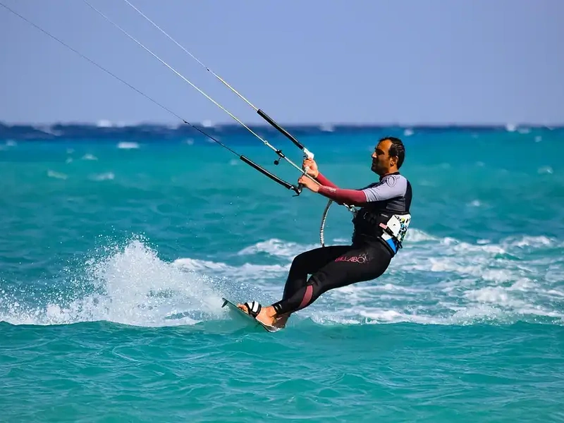 A man kitesurfing in the crystal-clear water of Khem Beach near Corona Resort & Casino Phu Quoc