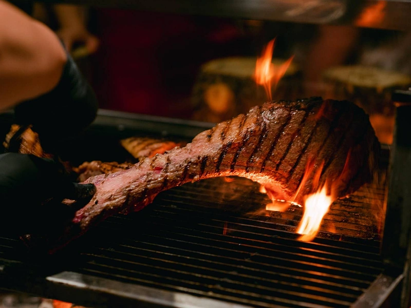 A premium bone-in Tomahawk steak sizzling over open flames, a highlight cut for steak in Phu Quoc dining close to Corona Resort & Casino Phu Quoc